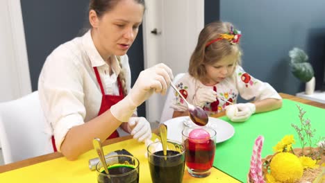madre e hija teñen huevos de pascua