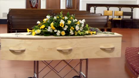 closeup shot of a funeral casket or coffin in a hearse or chapel or burial at cemetery