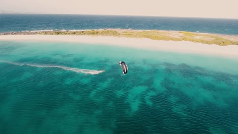 Aerial-View-Man-Kitesurfing-on-Caribbean-Sea,-being-carried-away-by-wind,-Los-Roques