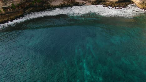 Vista-Aérea-Que-Avanza,-Vista-Panorámica-Del-Mar-Que-Se-Encuentra-Con-La-Orilla-Del-Acantilado-De-Tanjung-Ringgit