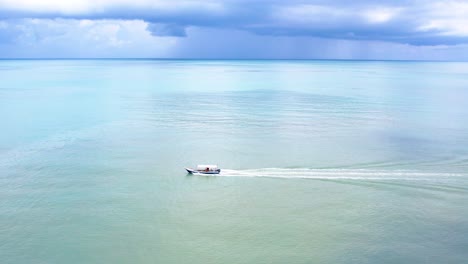 Eine-Schwenkaufnahme-Des-Segelns-Eines-Modernen-Motorboots-Auf-Einem-Ozean-Mit-Blauem-Himmelshintergrund-In-Der-Tageszeit