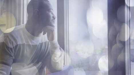 thinking deeply while looking out window, man over bokeh lights animation