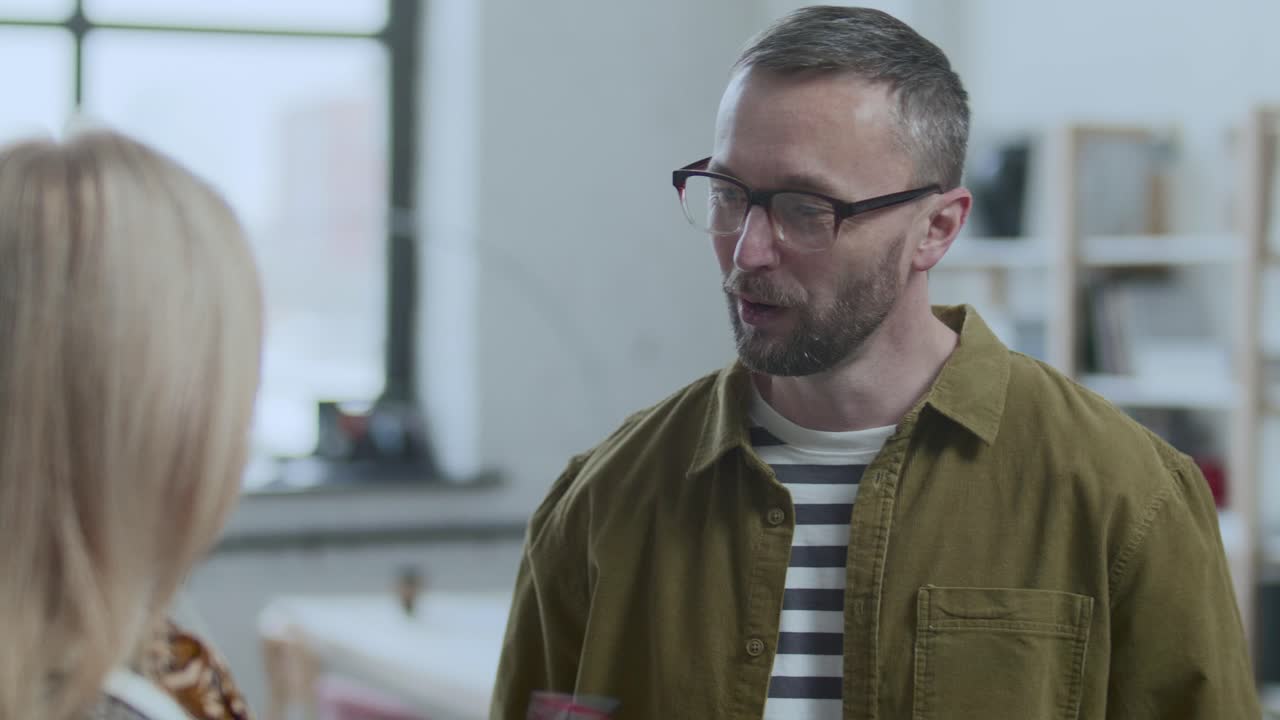 Businessman Talking to Female Colleague during Workday in Office