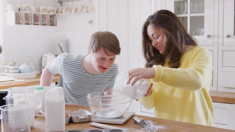 Young-Downs-Syndrome-Couple-Measuring-Ingredients-To-Bake-Cake-In-Kitchen-At-Home