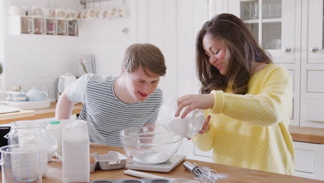young downs syndrome couple measuring ingredients to bake cake in kitchen at home