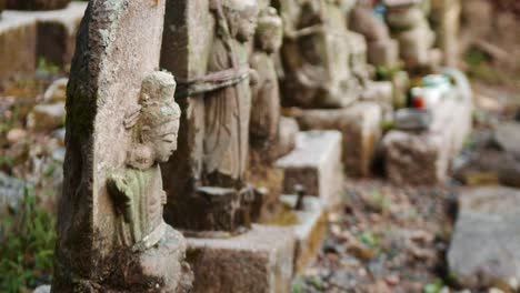 slide shot of small stone statues outside of a temple in kyoto, japan 4k slow motion