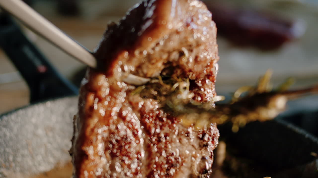 jugoso bistec de solomillo girado con pinzas de cocina y mantequilla fundida burbujeando