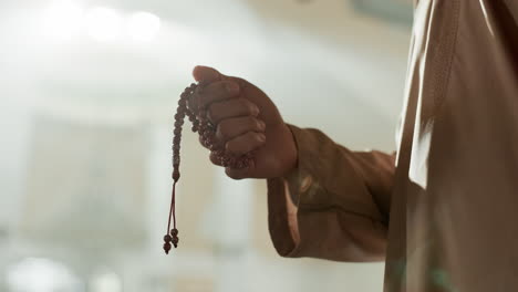 prayer, beads and hand of muslim man in mosque