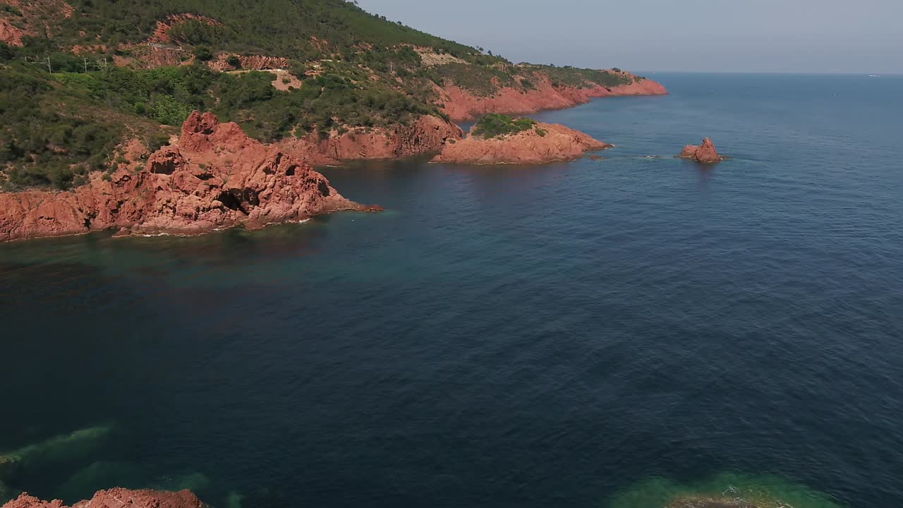 Deniz kenarındaki Antibes kırmızı kayalıkları manzarası üzerinde havadan dairesel çekim.
