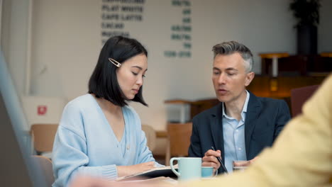 an young business woman check out her agenda with a businessman in a coffee shop 1