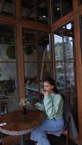 woman drinking coffee and using tablet in a cafe