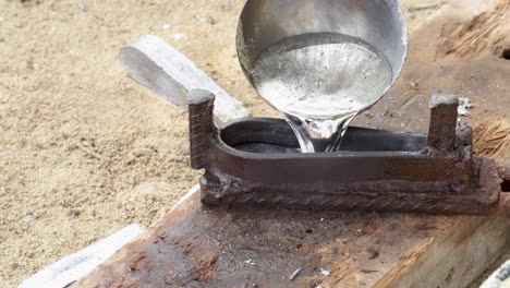 sinker moulding use ladle for pouring lead, handling hot molds, work outdoor, close up