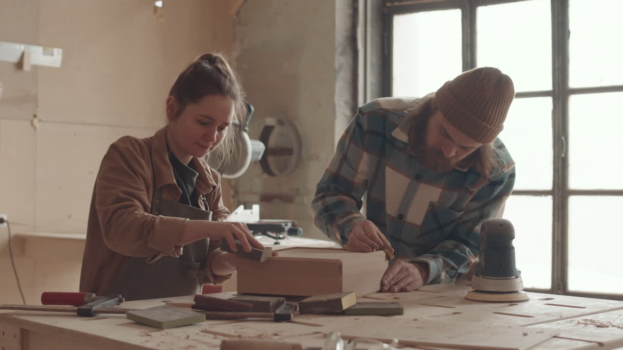 Two Joiners Polishing Wooden Box in Joinery Workshop