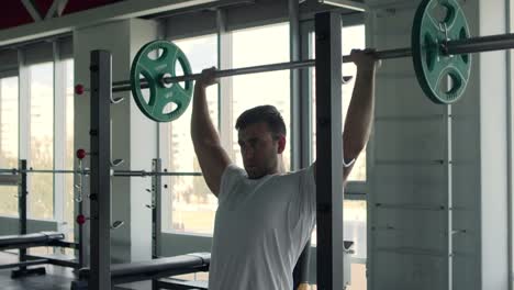 man performing shoulder press exercise in a gym