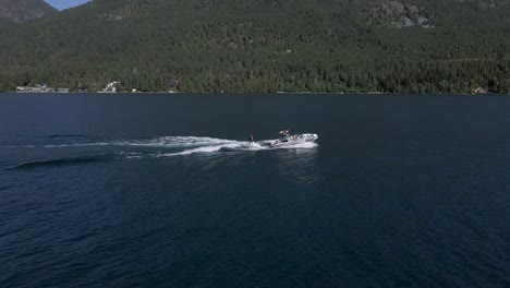 wakeboarder y remolcador con montañas en el fondo, montana - drone aéreo