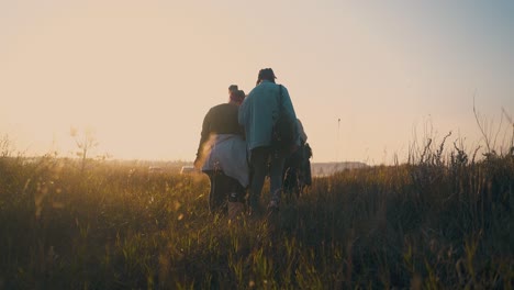 Los-Jóvenes-Caminan-Por-La-Pradera-Hasta-Los-Coches-Después-De-Una-Caminata-De-Un-Día.