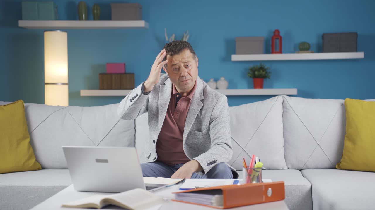 Uomo che lavora da casa che guarda la telecamera curioso e confuso