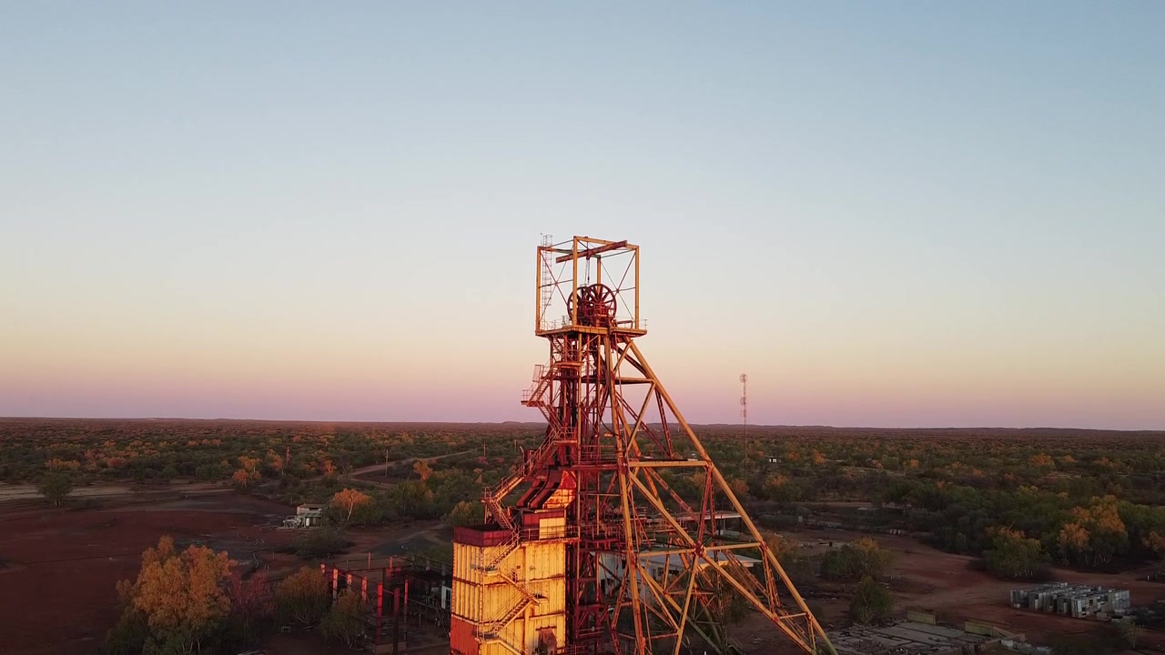 Ripresa in ascesa del castelletto di estrazione in una città mineraria abbandonata al tramonto. Località: Warrego, Territorio del Nord, Australia