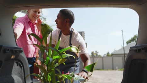 gardener discussing plant care with customer outside nursery, sharing gardening tips, in greenhouse
