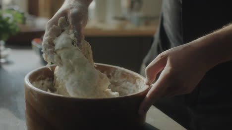 woman kneading dough in bowl