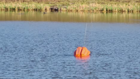 Bucket-On-A-Cable-Carried-By-A-Helicopter-Scoop-Water-In-The-River-To-Deliver-On-Wildfire-In-Fox-Creek,-Alberta,-Canada