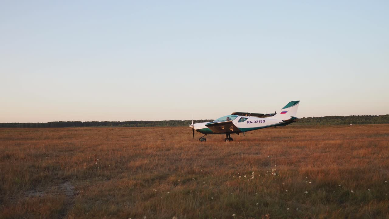 공항에서 비행기가 이륙하고 패러글라이더는 해가 지는  ⁇ 빛에 있습니다.