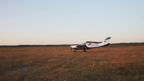 at the airport, the plane takes off and the paraglider is in the sunset sunlight