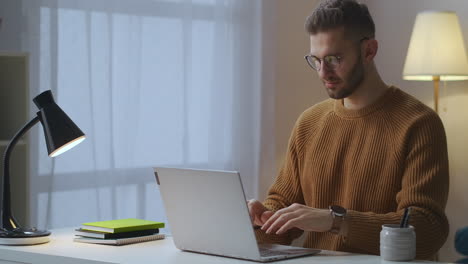 El-Hombre-Estira-Los-Brazos-Y-Los-Hombros-Y-Sigue-Escribiendo-En-El-Teclado-De-La-Computadora-Portátil-Trabajando-En-Gimnasia-Doméstica-Y-Relajándose-Durante-El-Trabajo-De-Oficina