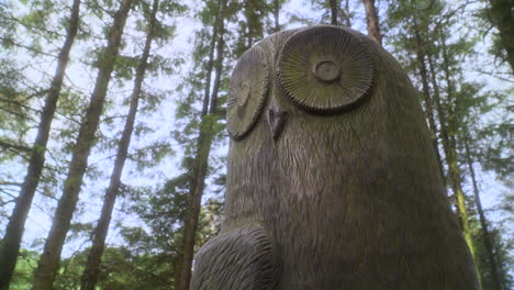 escultura de huevo de madera en el bosque inglés con la luz del sol cayendo sobre la escultura y pan muy lento