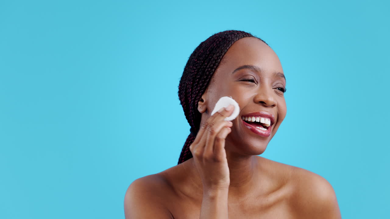 African woman, cotton and skincare in studio