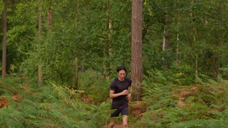 Tired Mid Adult Man Exercising Doing Work Out Outdoors Running Along Track Through Forest Stopping To Catch Breath Shot In Real Time