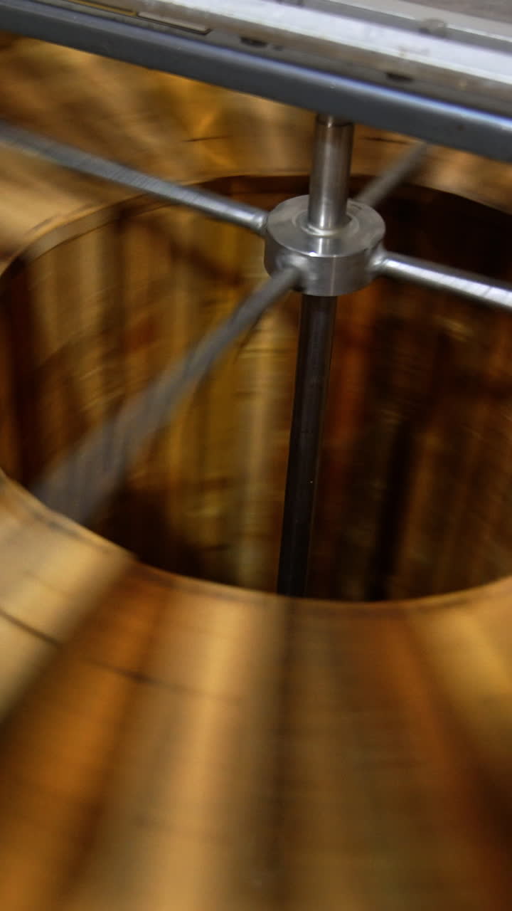 Honey extracting machine working. Honey frames are rotated in the apparatus to get fresh organic product. Close up. Vertical video