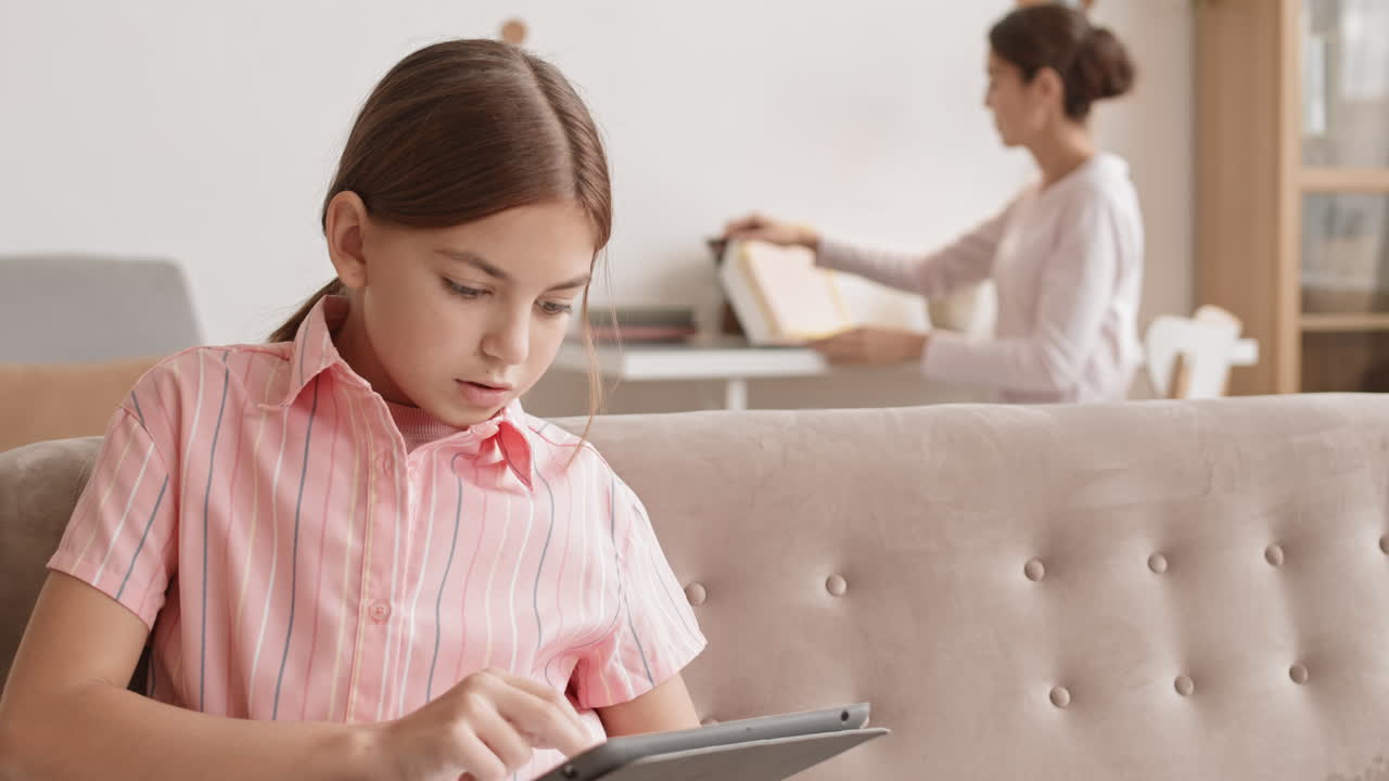 디지털 태블릿을 사용하는 백인 여학생과 그녀의 엄마