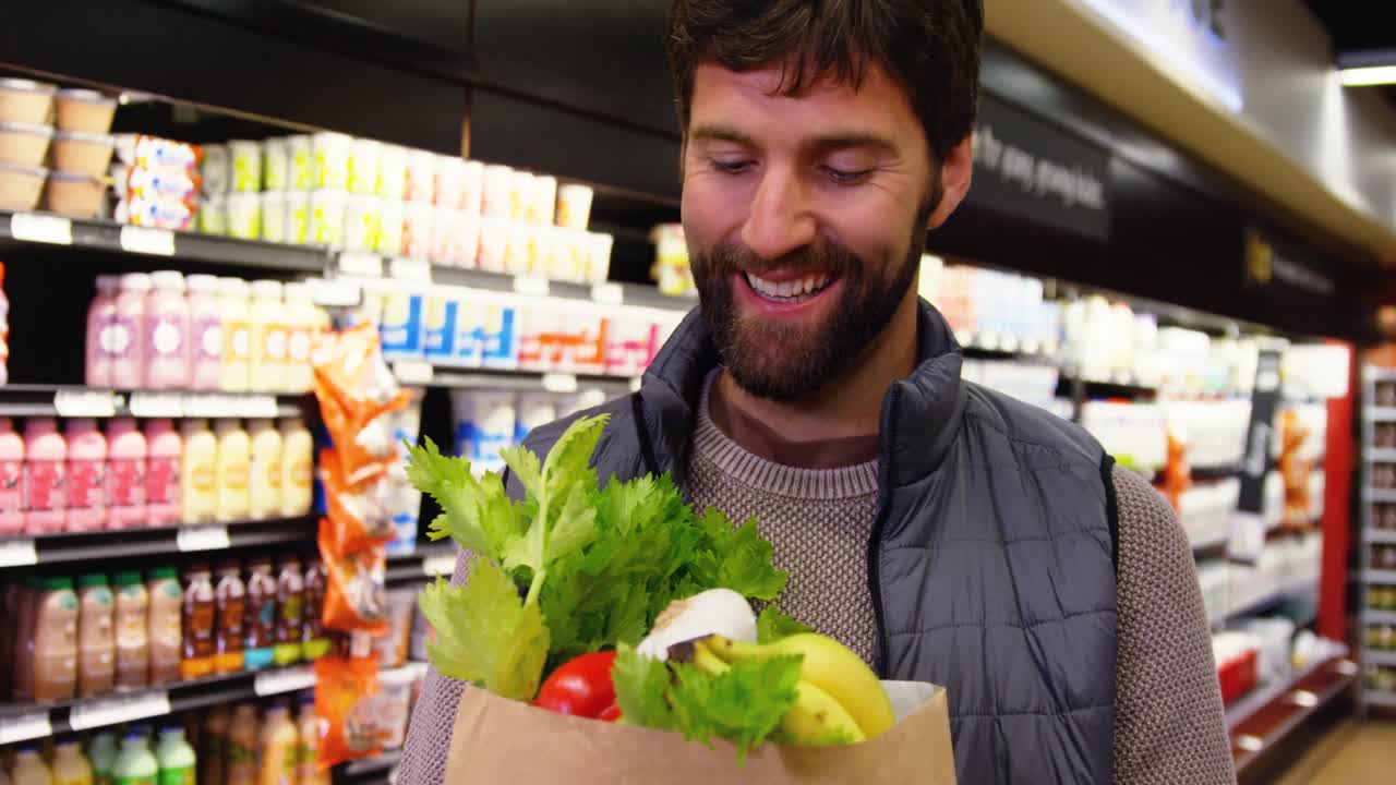 hombre sosteniendo frutas y verduras en una bolsa de papel