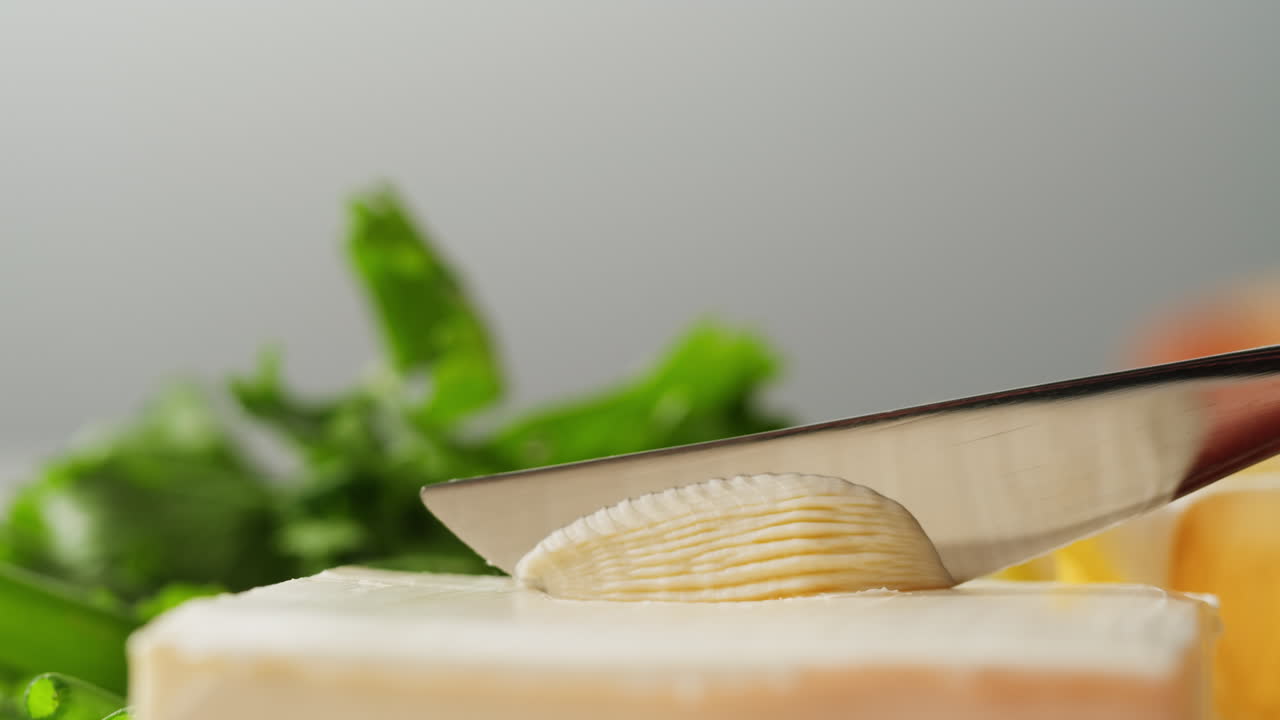 Young woman spreading nut butter onto toast in kitchen, closeup. High quality 4k footage