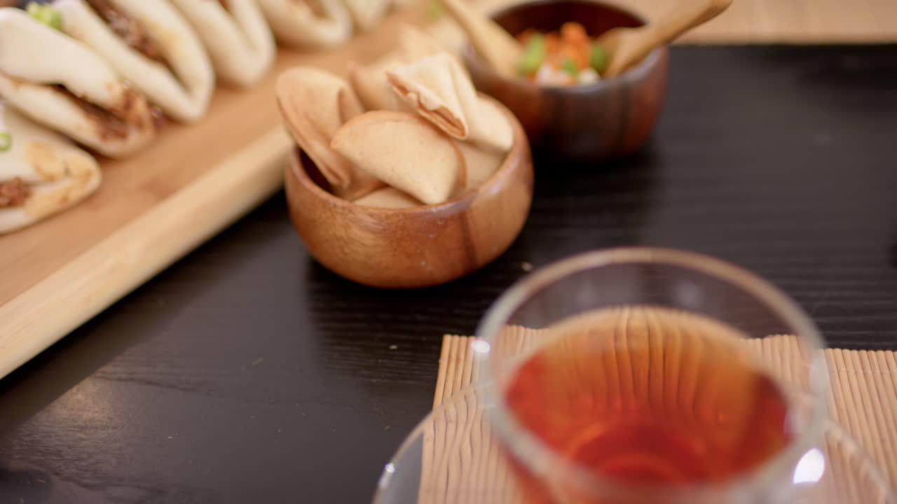 Enjoying cup of tea with snacks on wooden table, relaxing with friends