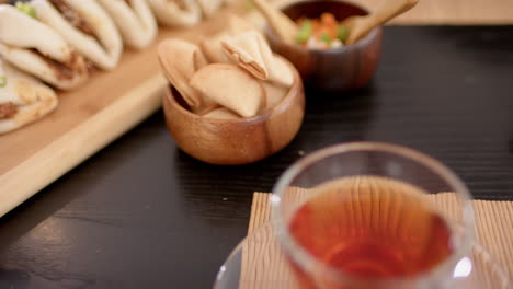 enjoying cup of tea with snacks on wooden table, relaxing with friends