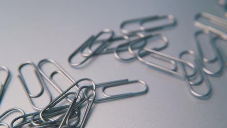 motion along pile of paperclips lying on grey background