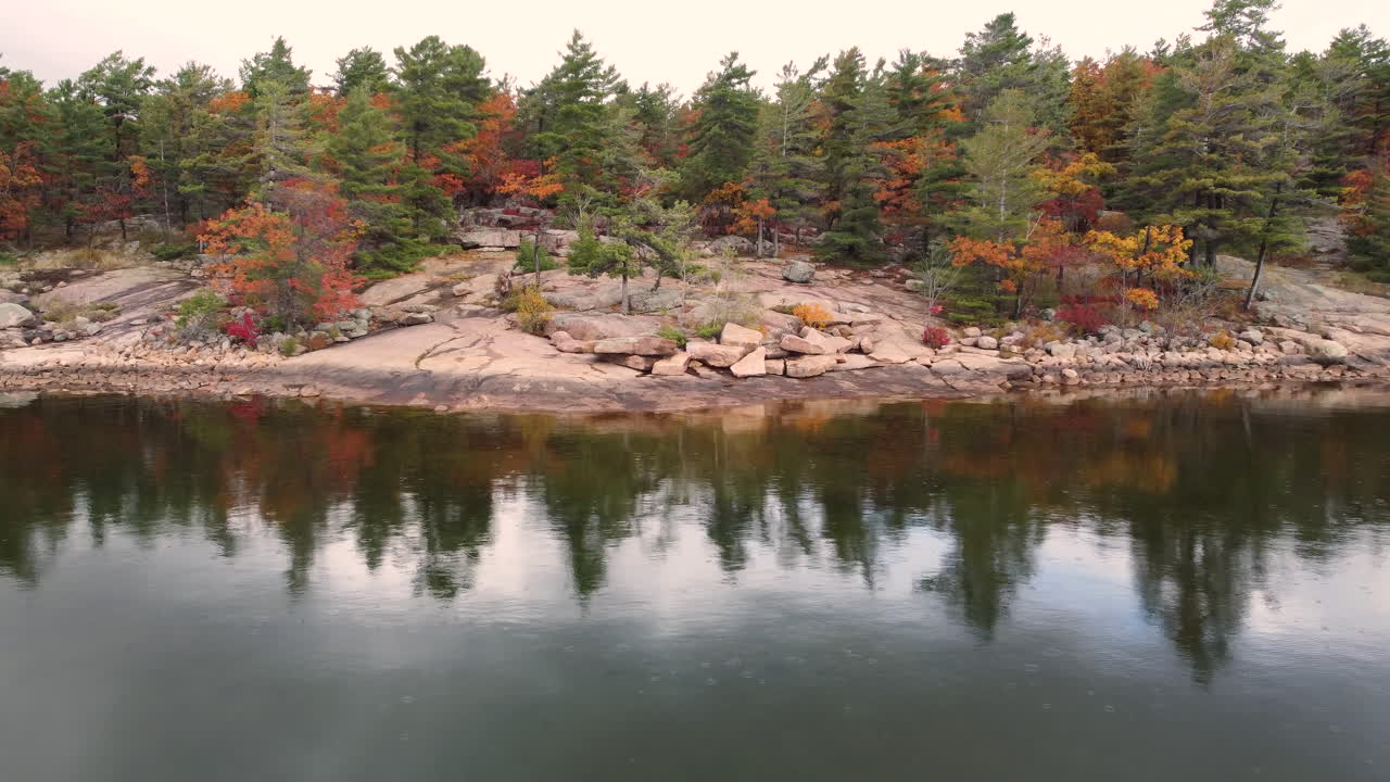 antena lenta sobre el lago reflectante hacia el bosque otoñal