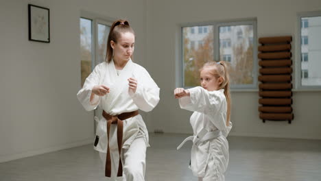 pupil and teacher in white kimono in martial arts class