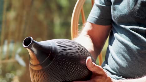 Man-looking-at-vase-made-by-skilled-potter