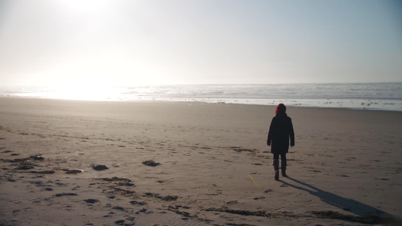 4k slow motion footage of woman walking alone on an empty beach while sunset - introverted - alone - enjoying freedom