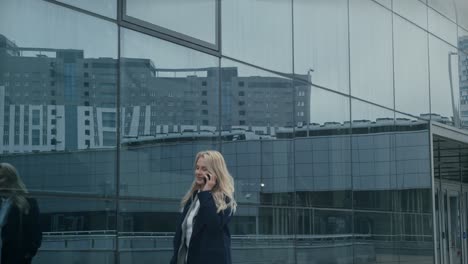 a woman walks outside, taking a phone call on a grey, overcast day