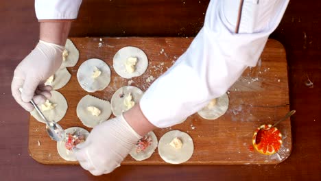 putting seafood filling on a dough, preparing homemade dumplings