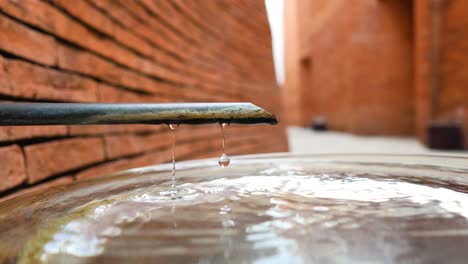 a droplet of water descends from a tap