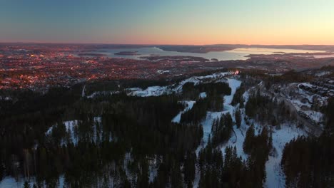 Holmenkollbakken cabin golden hour article circle sunset inlet Oslofjord Oslo Norway Norge aerial drone Norwegian coastline fHovedøya Hovedoya Holmenkollen ski jump cross country ski backwards motion