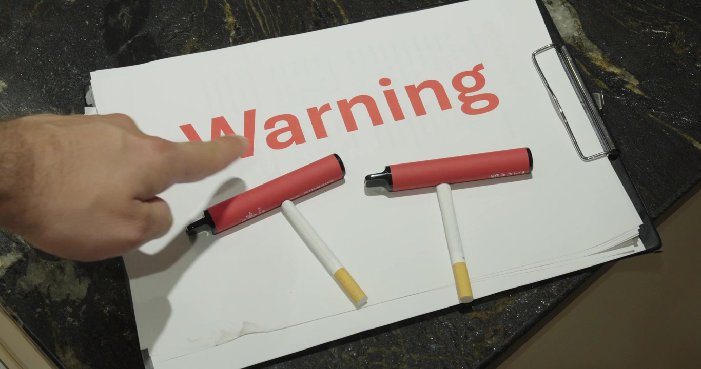 Warning sign with cigarettes and an electronic cigarette, illustrating the health risks of smoking, vaping, and nicotine addiction.