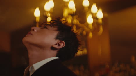 man looking up at a chandelier