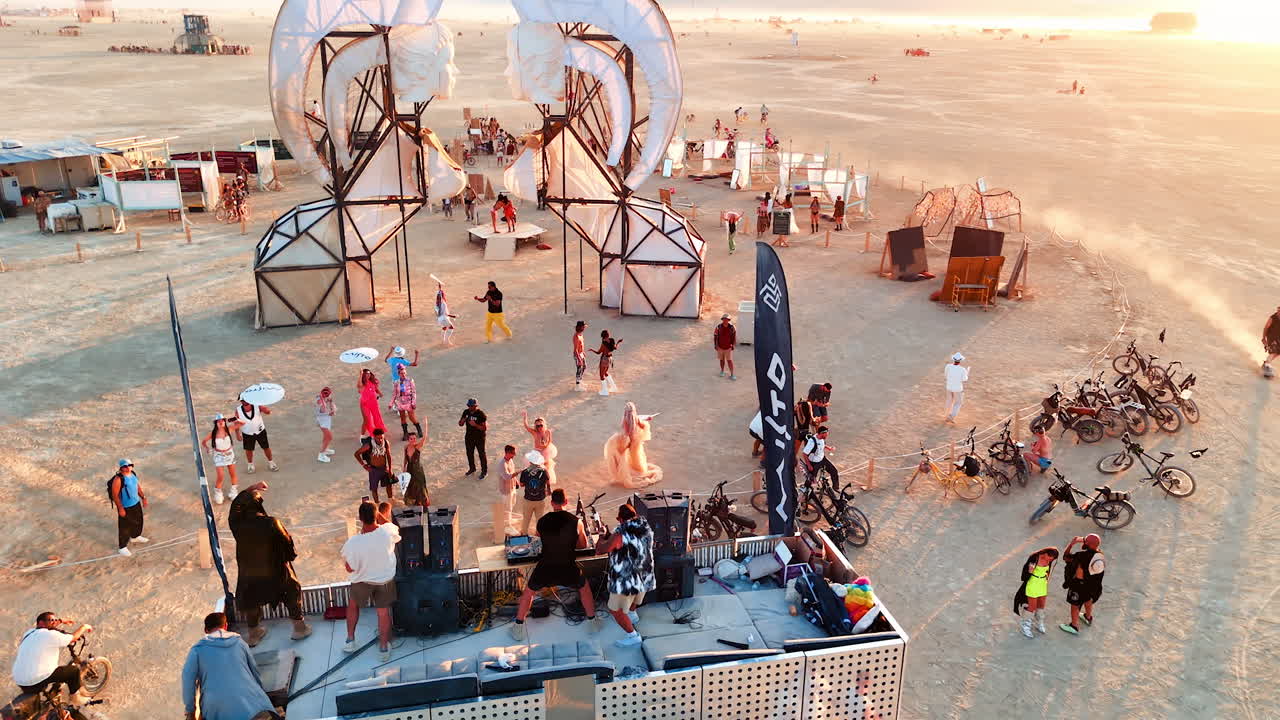 Nevada, USA, 22 August 2025: People around Burning Man art structure at sunset. Visitors gather around a large symbolic art structure at Burning Man during sunset