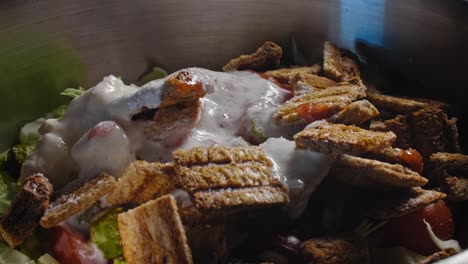 close up of a tuna salad in a metal bowl while seasonings are being added